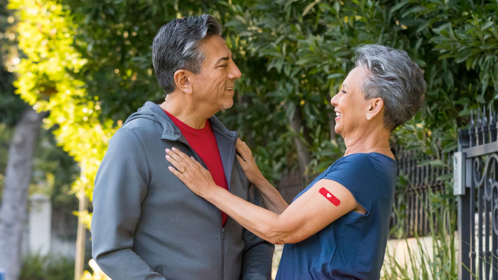 A senior man and a woman who has a CVS heart bandage on her upper arm over her RSV vaccination site.