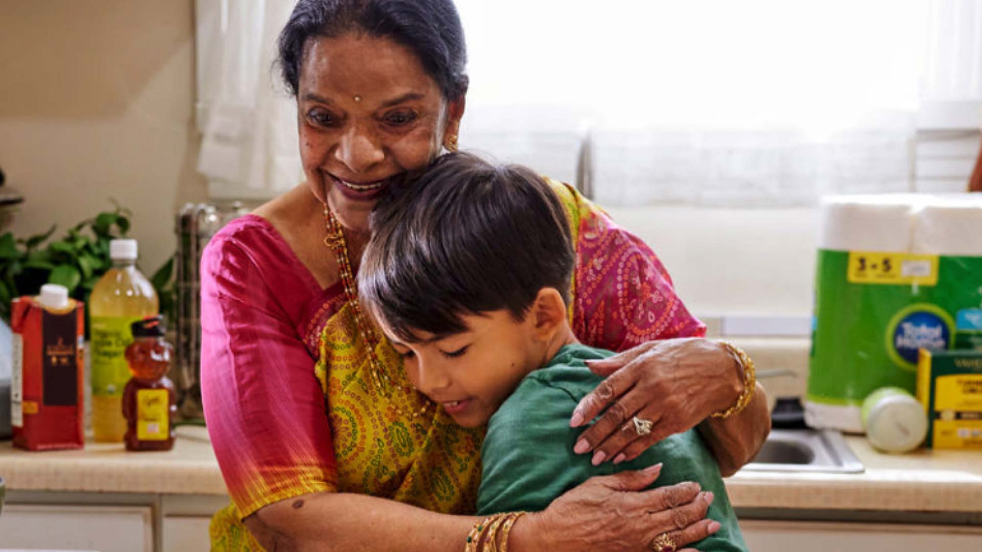 A grandparent hugging their grandchild.
