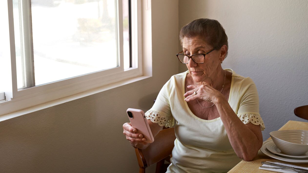 A woman takes a treatment screener on her phone.