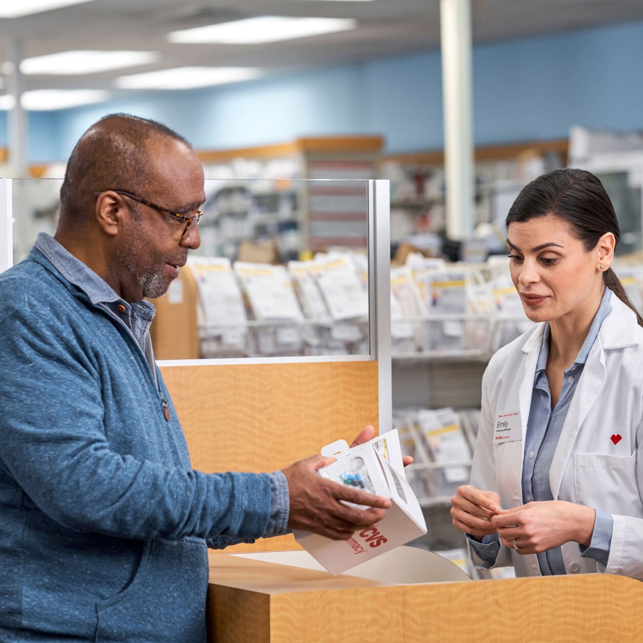 A CVS pharmacist explains the details of a patient’s prescription with him.