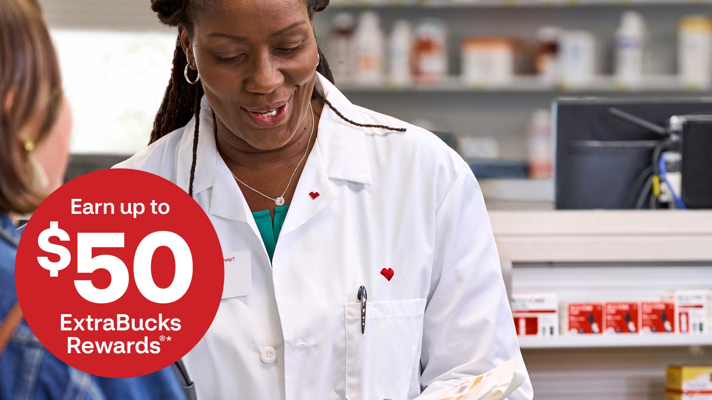 Earn up to $50 ExtraBucks Rewards. CVS pharmacist reviewing a prescription with a patient.